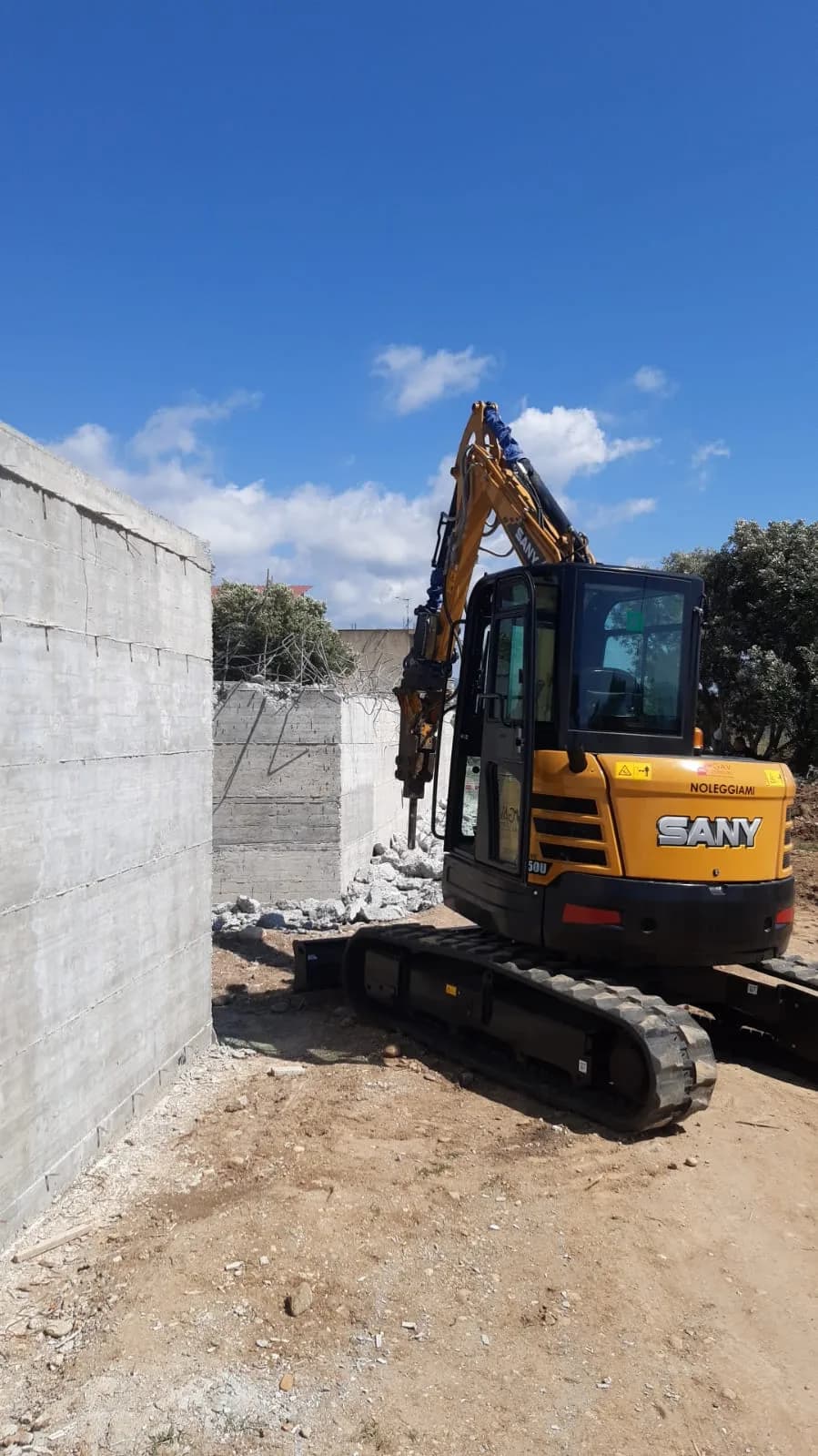 Escavatore con martello demolitore in cantiere